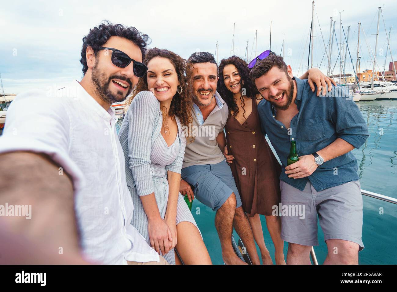 Selfie-Spaß in der Gruppe auf dem Bootsdeck – Eine Gruppe von Freunden hält einen lustigen und unvergesslichen Moment mit einem Selfie in der Gruppe auf dem Deck eines Bootes fest. Ihr Lächeln und laug Stockfoto