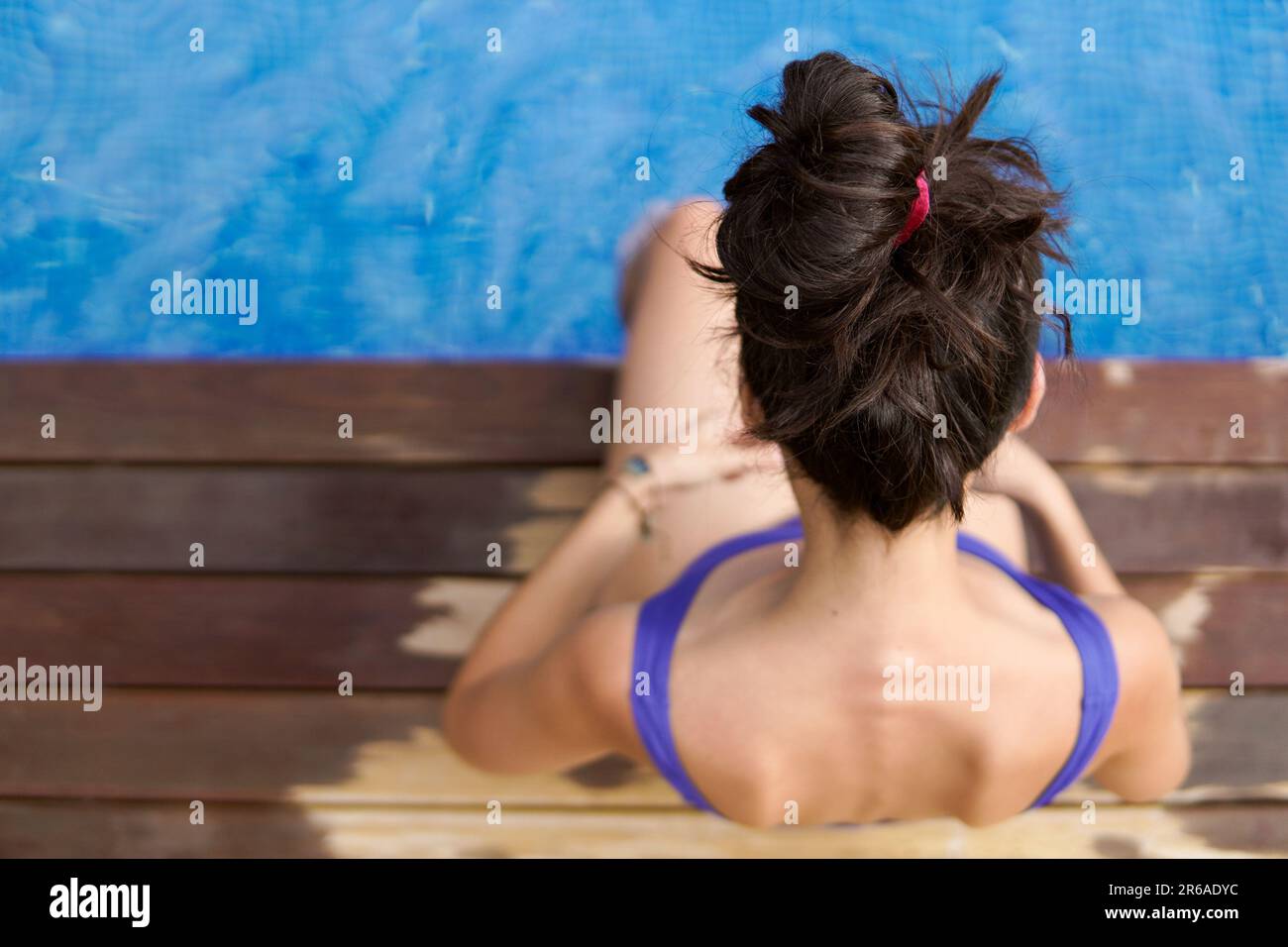 Luftaufnahme einer schlanken Frau, die im Pool sitzt Stockfoto