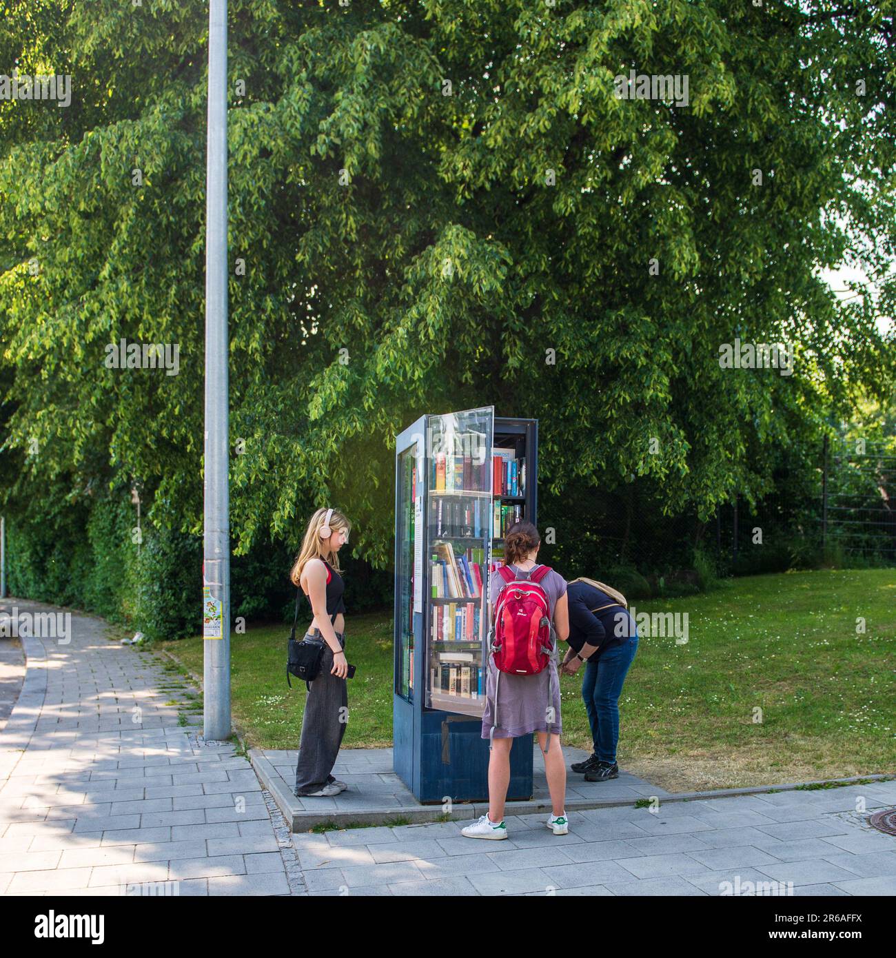 München, Deutschland-Juni 8,2023: Die Menschen schauen in einem Buchtauschkiosk auf Bücher Stockfoto