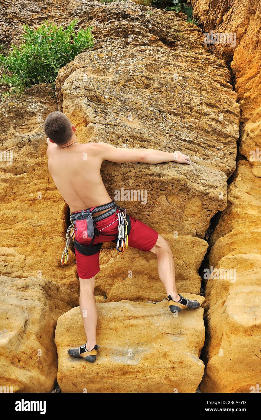 Muskelkletterer klettert auf Felsen Stockfoto