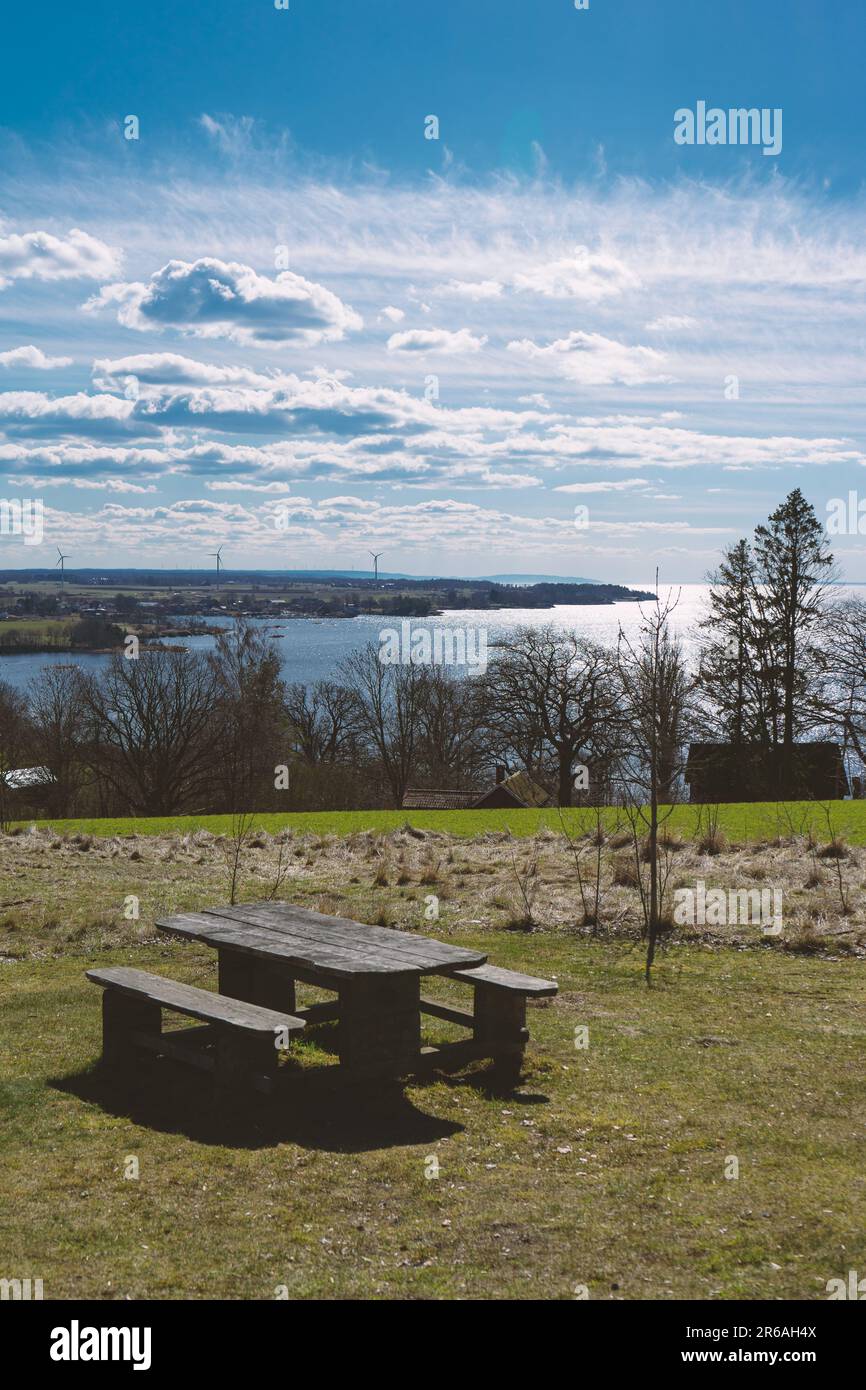 Eine Bank in einem Feld mit Blick auf einen See Stockfoto