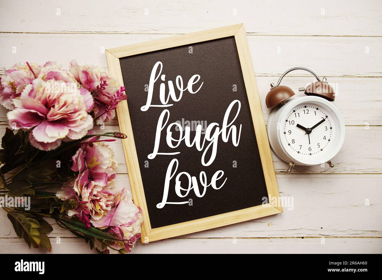 Live Lough Love Textnachricht mit Weckruf und Blumendekoration auf Holzhintergrund Stockfoto