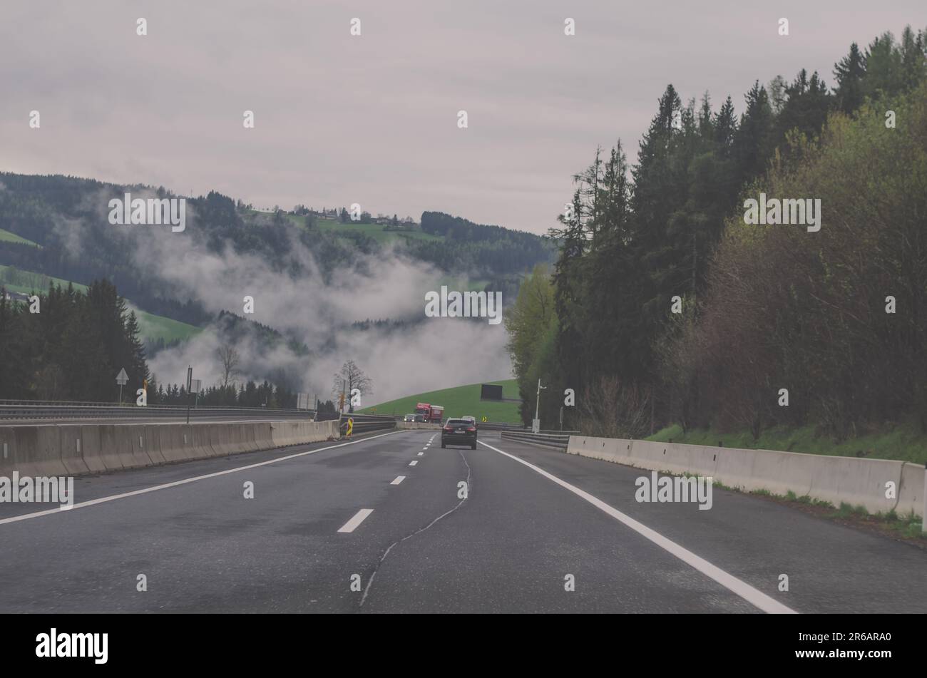 Auto auf der Straße in der malerischen Landschaft zu nebligen Nachmittagszeit Stockfoto