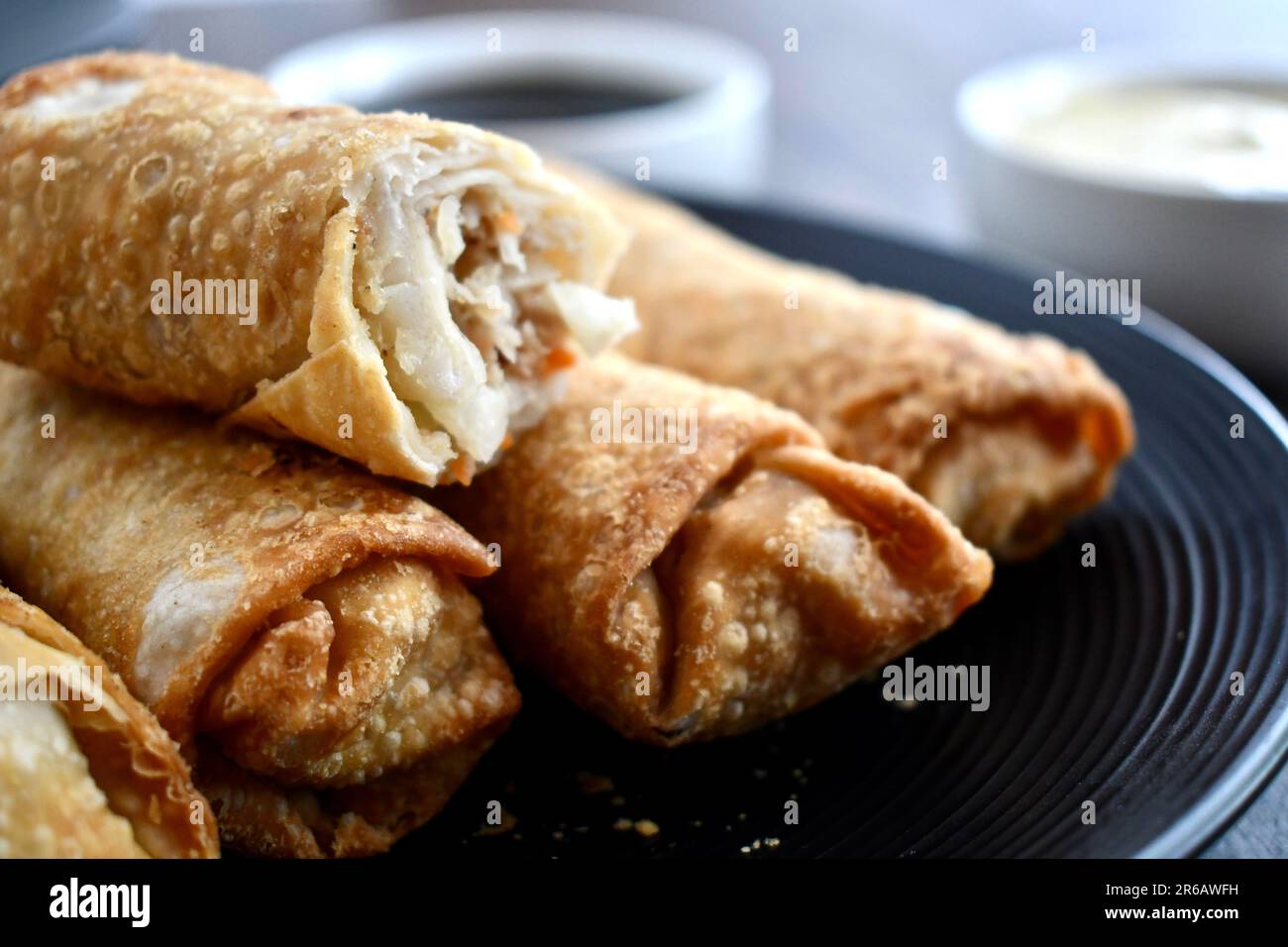 Frühlingsrollen auf einem schwarzen Teller Stockfoto