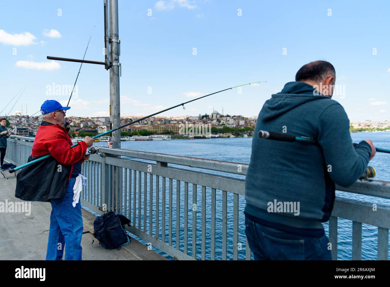 Istanbul, Türkei - 10. Mai 2023: Fischer werden mit ihrer Angelrute über der berühmten Galata-Brücke am Bosporus beim Fischen gesehen. Szene des täglichen Lebens Stockfoto