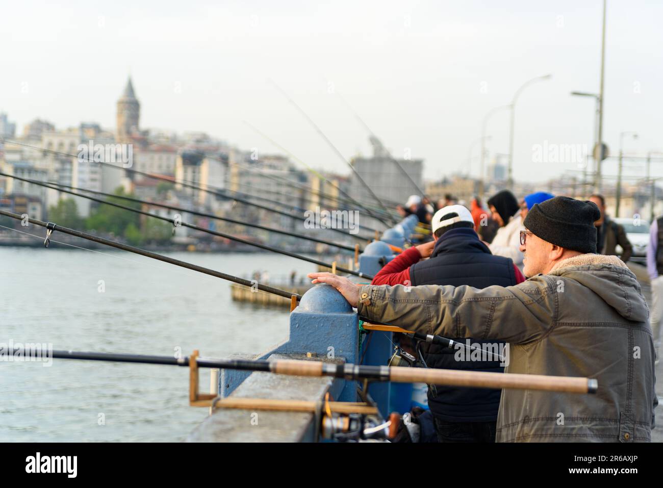 Istanbul, Türkei - 10. Mai 2023: Fischer werden mit ihrer Angelrute über der berühmten Galata-Brücke am Bosporus beim Fischen gesehen. Szene des täglichen Lebens Stockfoto