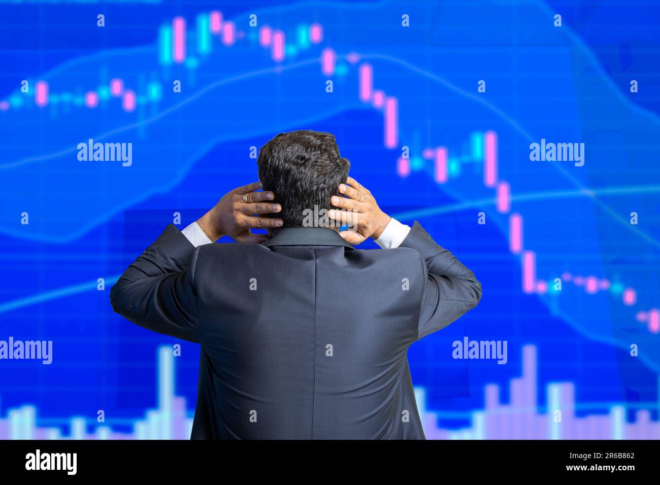 Der Stressaktienhändler schaut auf den Bildschirm und zeigt eine Grafik mit Kerzenleuchtern, die nach unten geht, Finanzmarktkollaps. Stockfoto