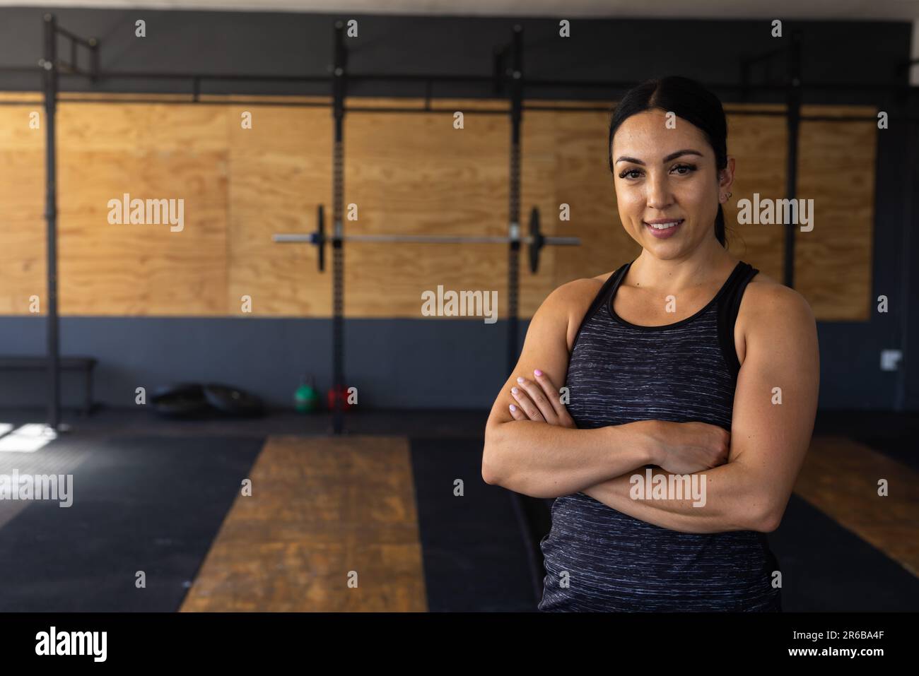 Porträt einer selbstbewussten jungen Frau mit gekreuzten Armen im Fitnessclub Stockfoto
