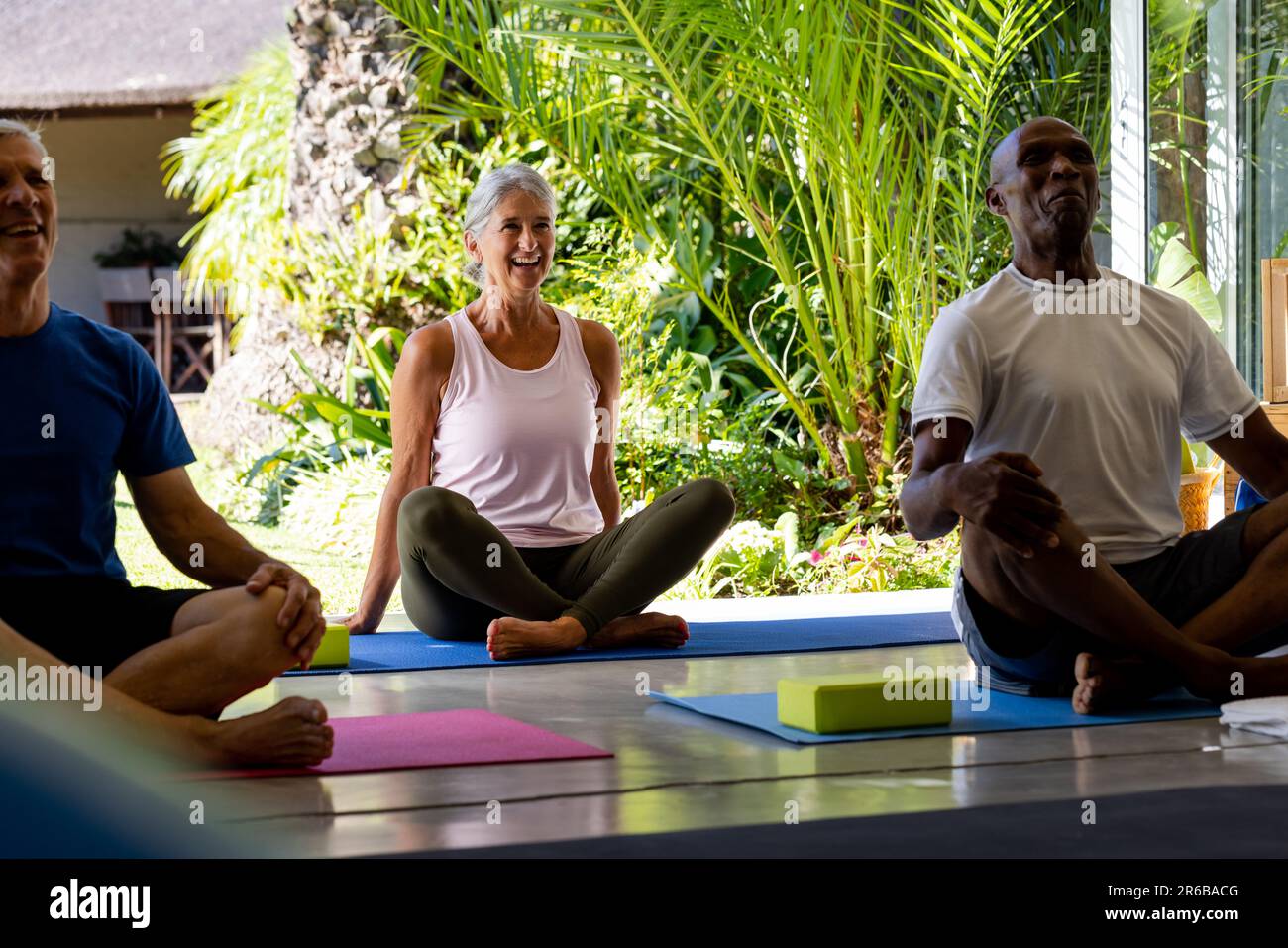 Fröhliche, vielfältige Senioren, die im Pilates-Kurs trainieren Stockfoto