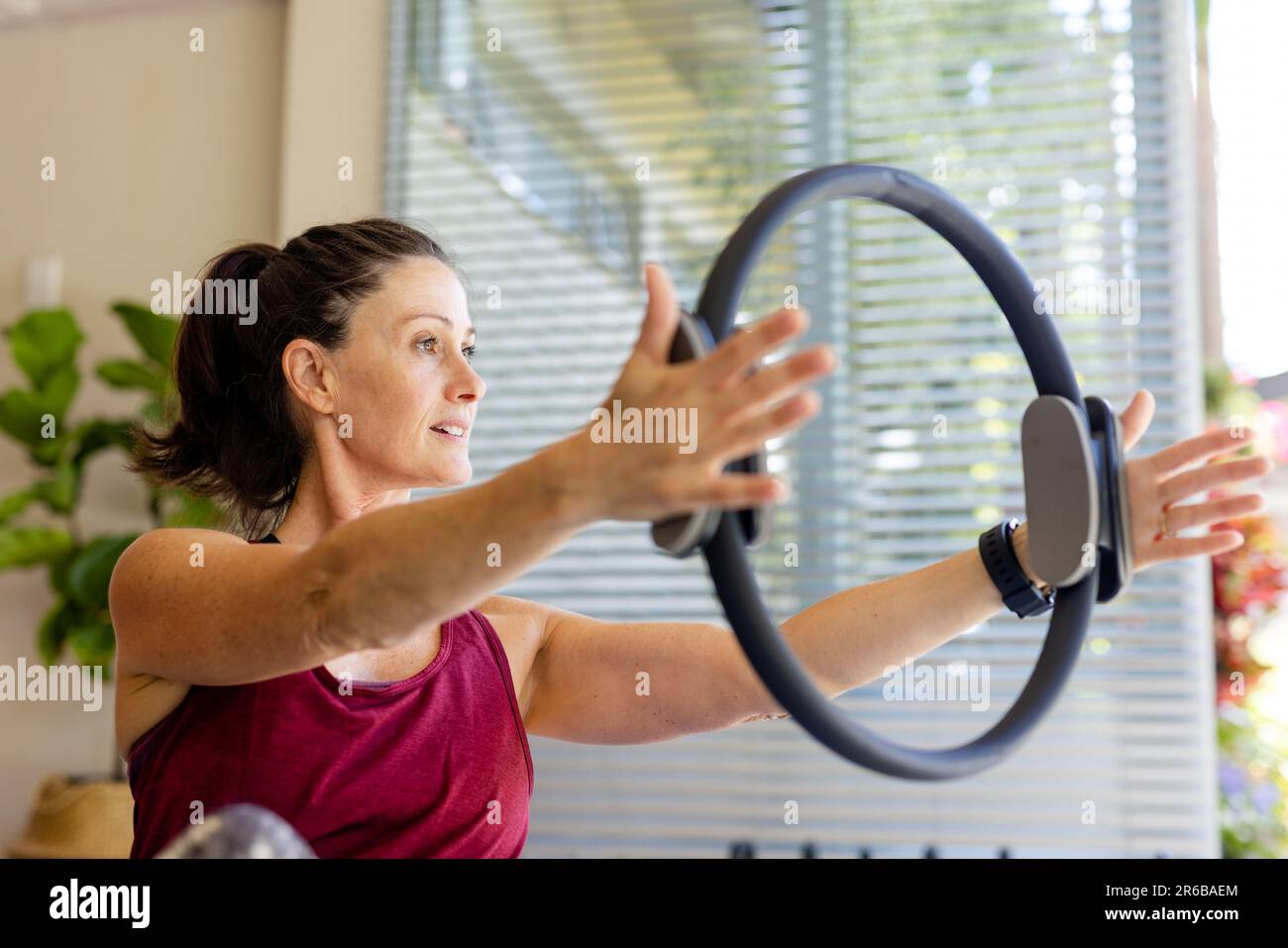Fokussierte kaukasische Trainerin mit Trainingsring im Pilates-Kurs Stockfoto