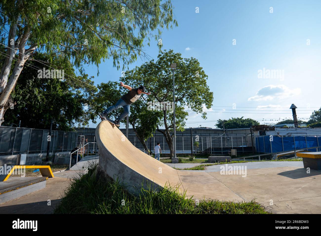 San Salvador, San Salvador, El Salvador - 11. November 2022: Junger brauner Mann mit einer Mütze macht einen schwachen Stall-Trick auf einer Betonviertelpfeife auf einem Skat Stockfoto San Salvador, San Salvador, El Salvador - 11. November 2022: Junger brauner Mann mit einer Mütze macht einen schwachen Stall-Trick auf einer Betonviertelpfeife auf einem Skat Stockfoto