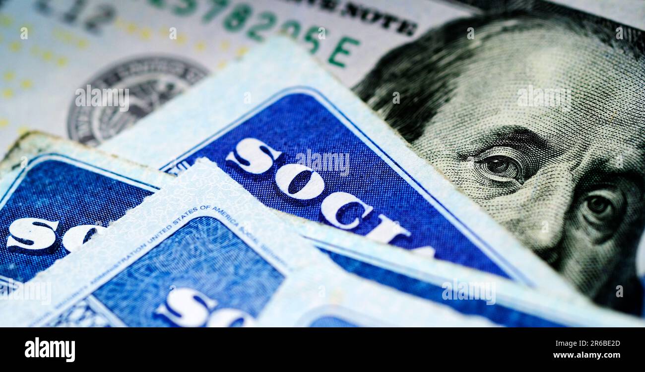 Mehrere Sozialversicherungskarten auf einem US-amerikanischen hundert-Dollar-Schein $100 System von Sozialleistungen für Rentner Stockfoto
