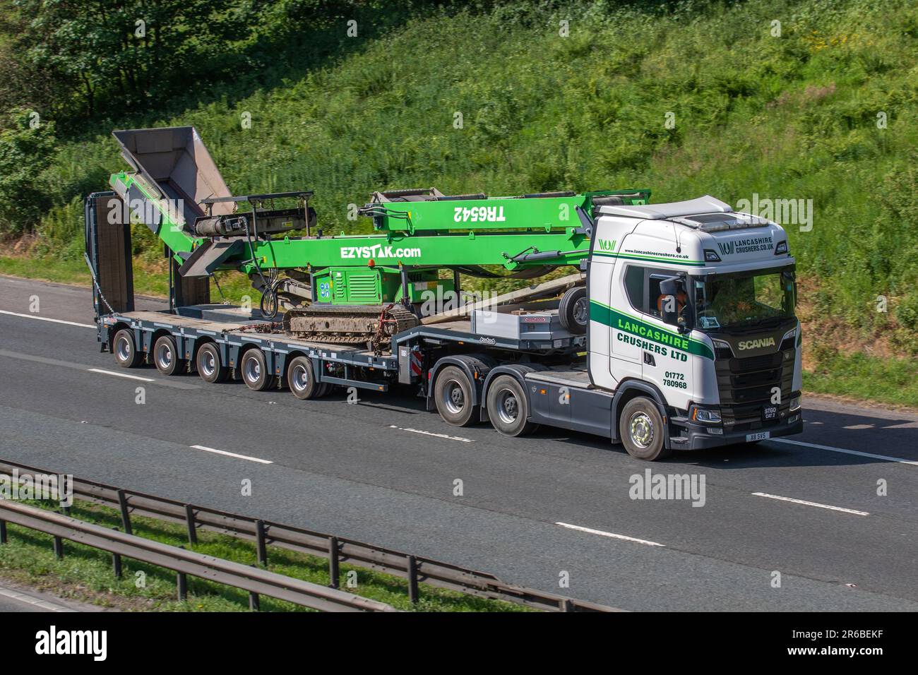 EZYSTAK.com, Ezystak Conveyors wird von LANCASHIRE CRUSHERS Ltd. SCANIA HGV auf der Autobahn M61 UK auf Nooteboom Tieflader transportiert Stockfoto