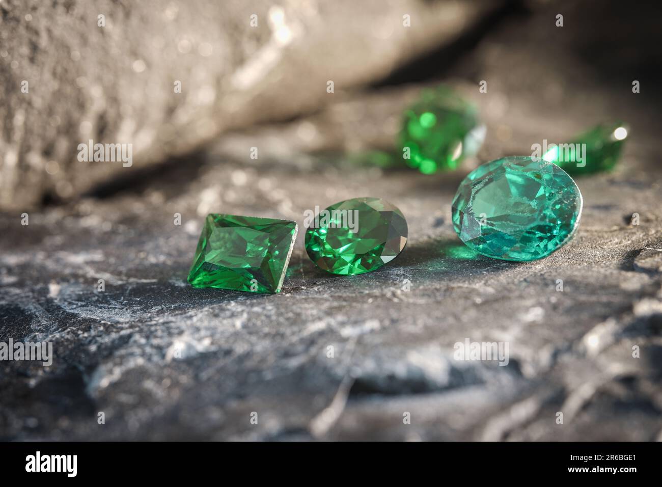 Die glitzernden natürlichen grünen Saphirsteine auf einer rauen Felsoberfläche Stockfoto