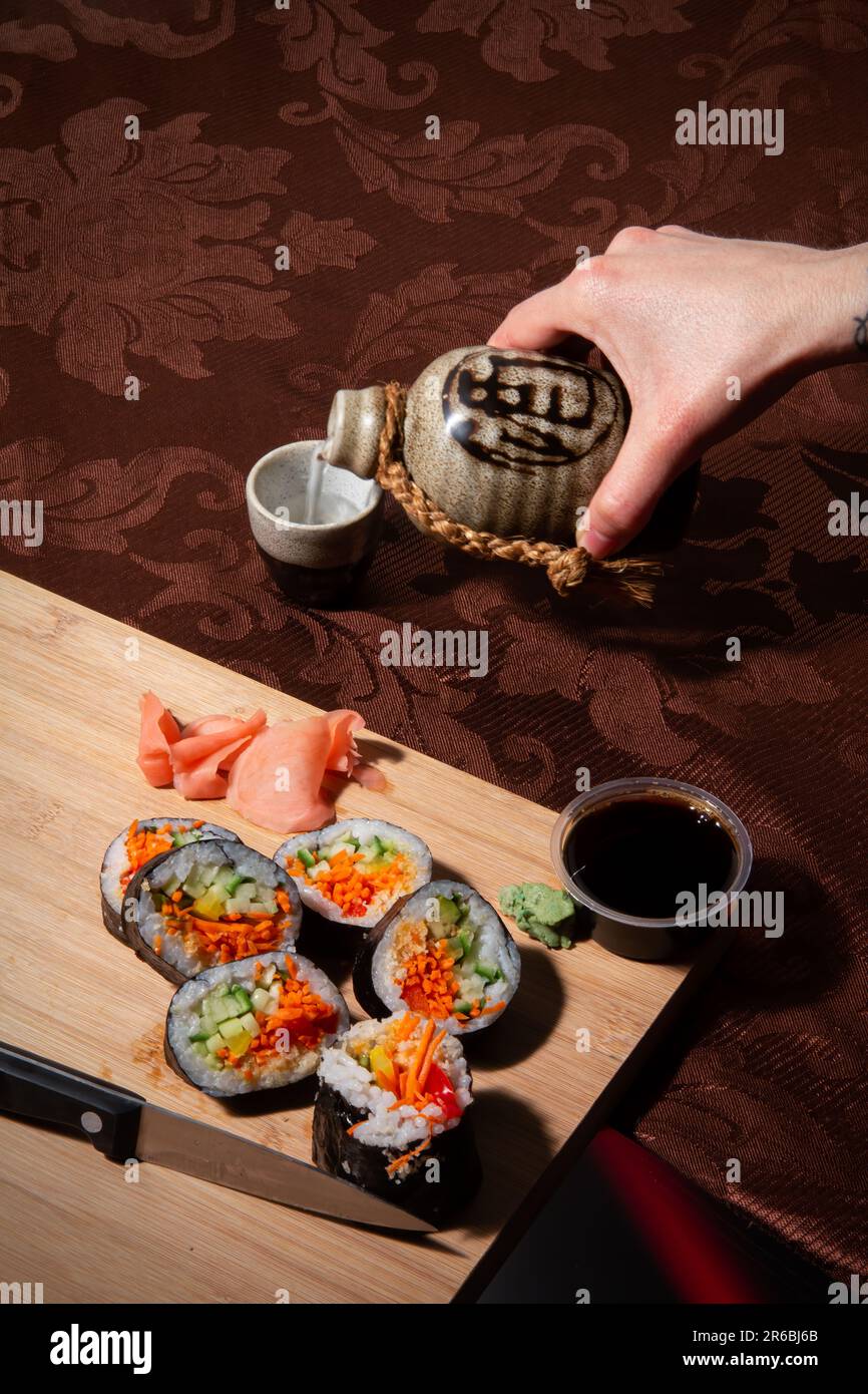 Traditionelle japanische Küche. Sushi-Brötchen auf einem Holzbrett Stockfoto