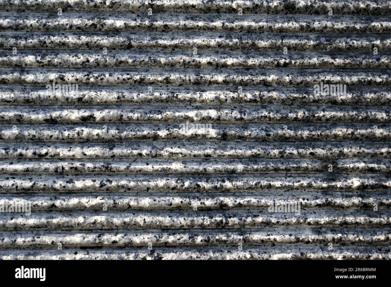 Horizontale Streifen aus Granit. Dunkelgrau gestreifte Hintergrundstruktur. Stockfoto
