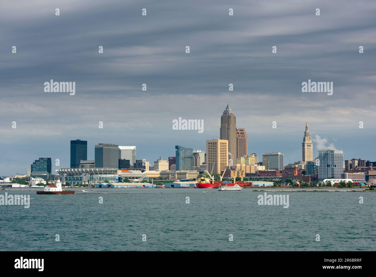 Die Skyline von Cleveland kann von einem Kreuzfahrtschiff auf dem Eriesee unter grauen Wolken gesehen werden, aber mit Sonnenlicht, das von der Plattform einfällt Stockfoto