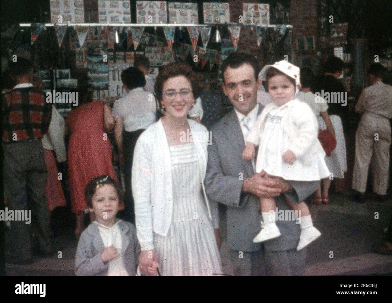 1950er – eine Familie im Urlaub posiert für ein Foto vor einem Souvenirverkäufer, Geschäften, einem 8-mm-Minox-Film-Diascan Stockfoto