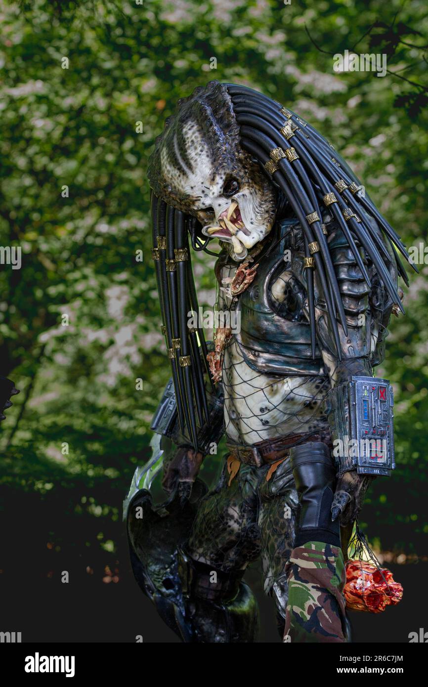 HARROGATE, GROSSBRITANNIEN - 3. JUNI 2023. Ein Porträt eines Cosplayer, gekleidet als außerirdischer Raubtier in realistischen Kostümen im Freien in einer Waldumgebung Stockfoto
