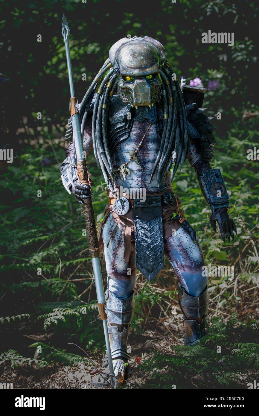 HARROGATE, GROSSBRITANNIEN - 3. JUNI 2023. Ein Porträt eines Cosplayer, gekleidet als außerirdischer Raubtier in realistischen Kostümen im Freien in einer Waldumgebung Stockfoto