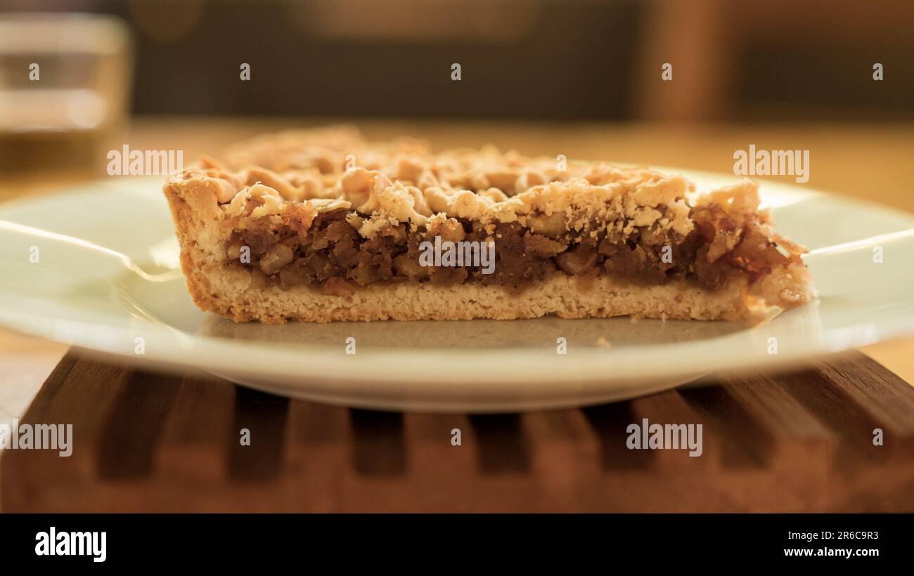 Selektiver Fokus einer Apfelkuchen-Scheibe auf weißem Teller. Nahaufnahme des Desserts. Stockfoto