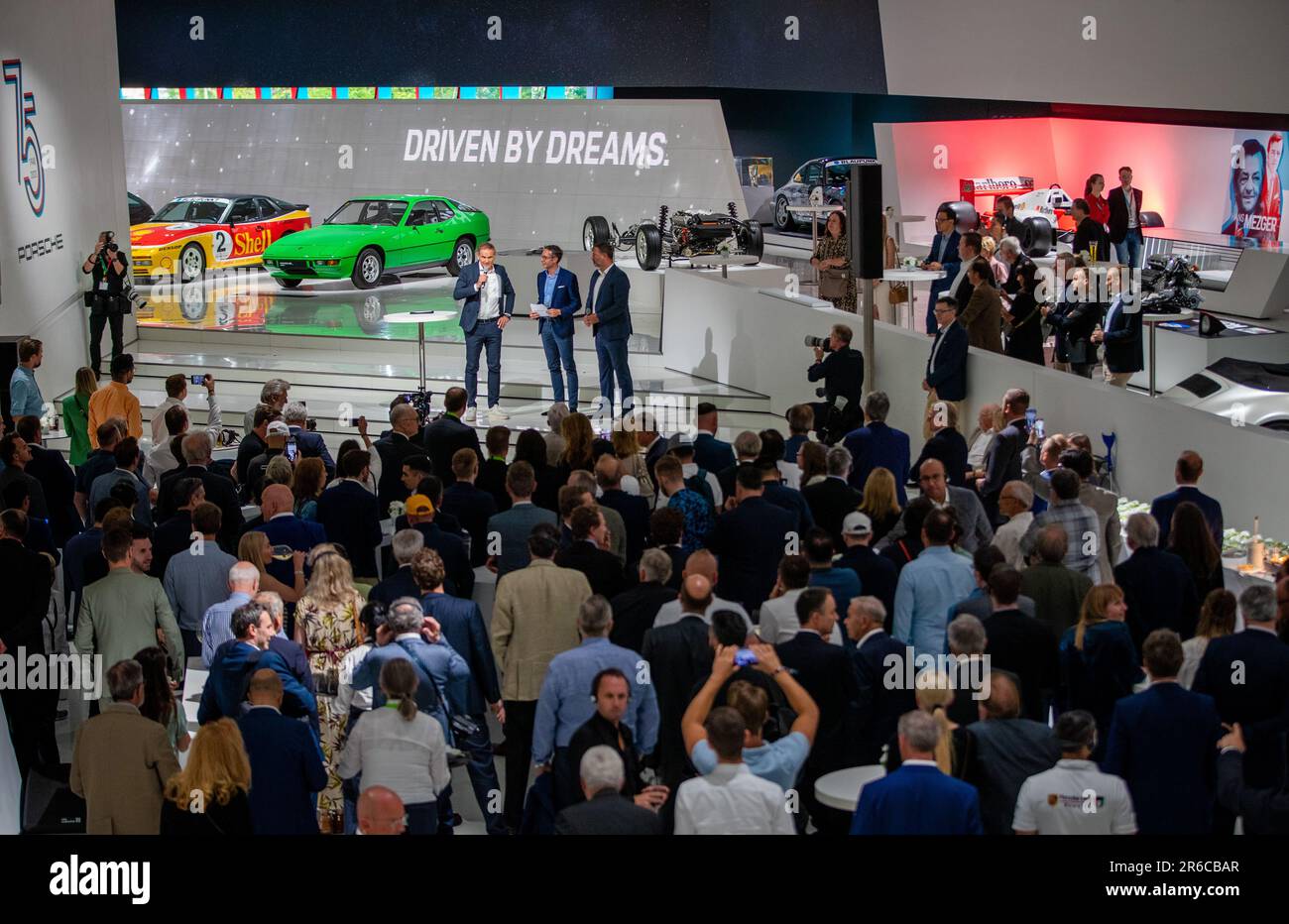 Stuttgart, Deutschland. 08. Juni 2023. Zahlreiche Gäste beobachten die Eröffnung der Sonderausstellung „Driven by Dreams“ während der feierlichen Veranstaltung zu 75 Jahren Porsche-Sportwagen im Firmenmuseum Stuttgart-Zuffenhausen. Kredit: Christoph Schmidt/dpa/Alamy Live News Stockfoto