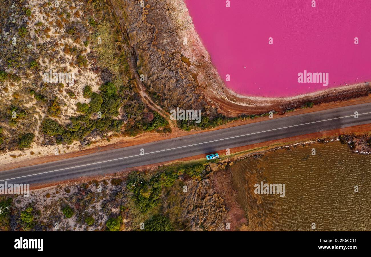 Pink Lake in Port Gregory in Westaustralien, farbenfrohes Wasser mit Bakterien und Algen, wunderschöner Kontrast zwischen dem blauen Ozean und dem rosa Wasser, Wolken Stockfoto