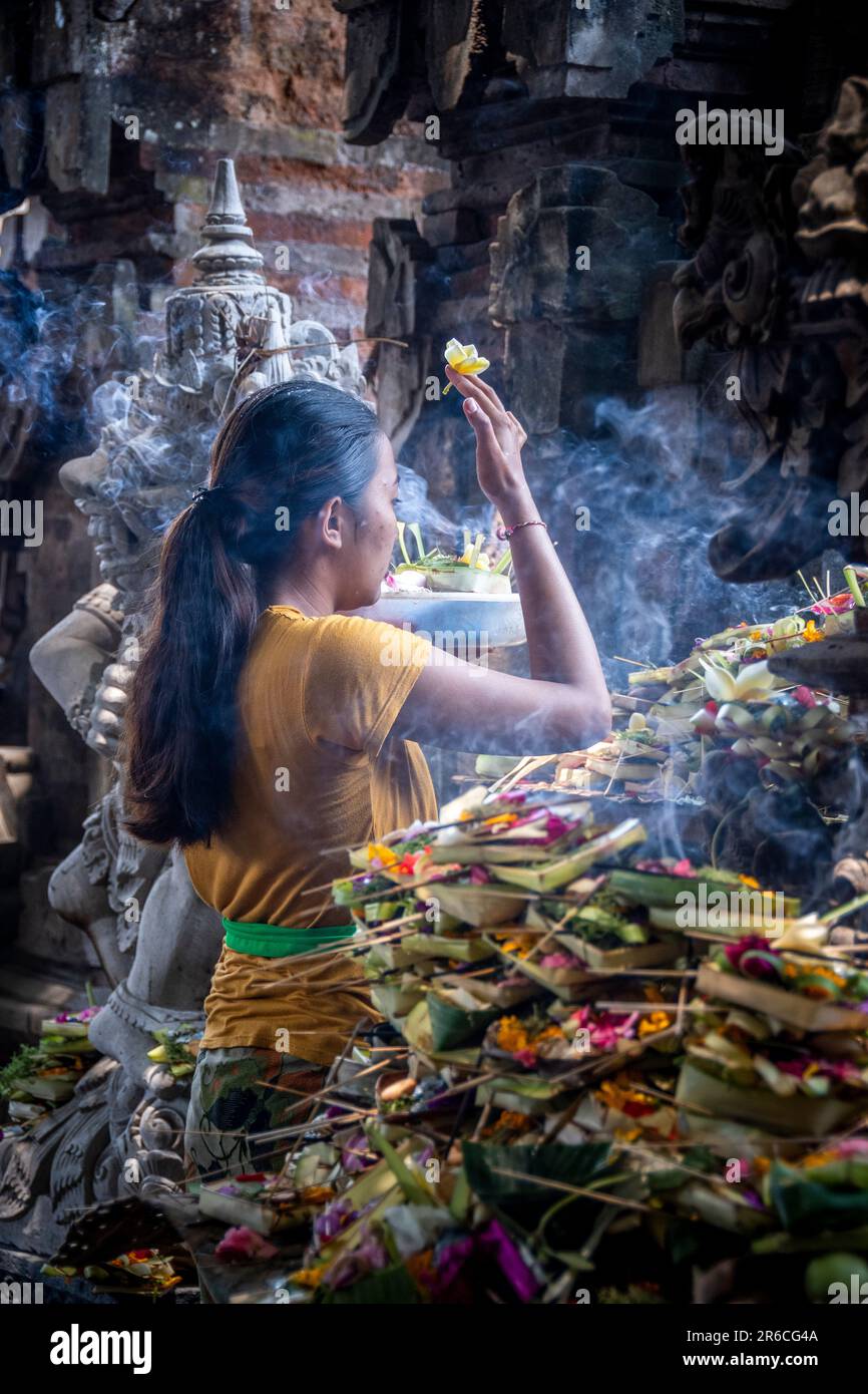 Eine Frau macht ein Opfer in einem Tempel in Ubud, Bali, Indonesien Stockfoto