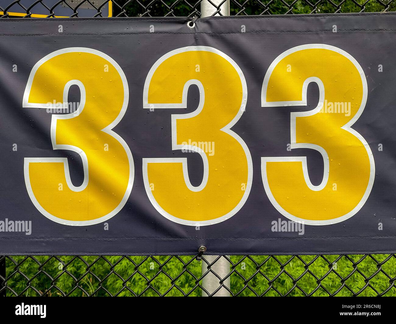 333 m großes Schild in Gelb und Schwarz auf dem schwarzen Vinyl-Außenfeldzaun. Stockfoto
