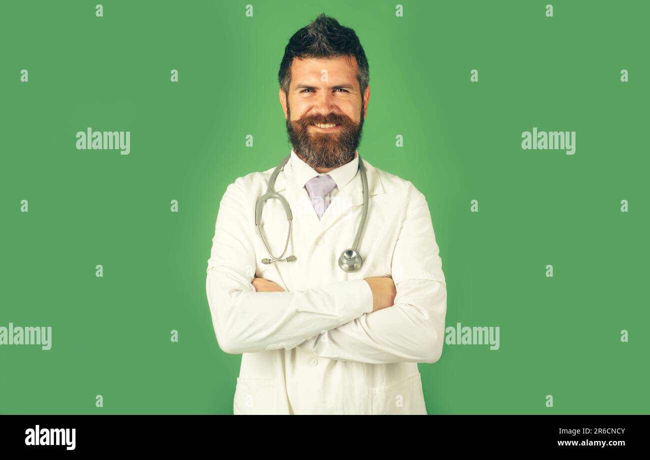 Gesundheitswesen, medizinisches Personal Konzept. Porträt eines lächelnden Arztes in Arbeitskleidung mit gekreuzten Armen. Arzt im weißen Arztröbchen mit Stethoskop am Hals Stockfoto