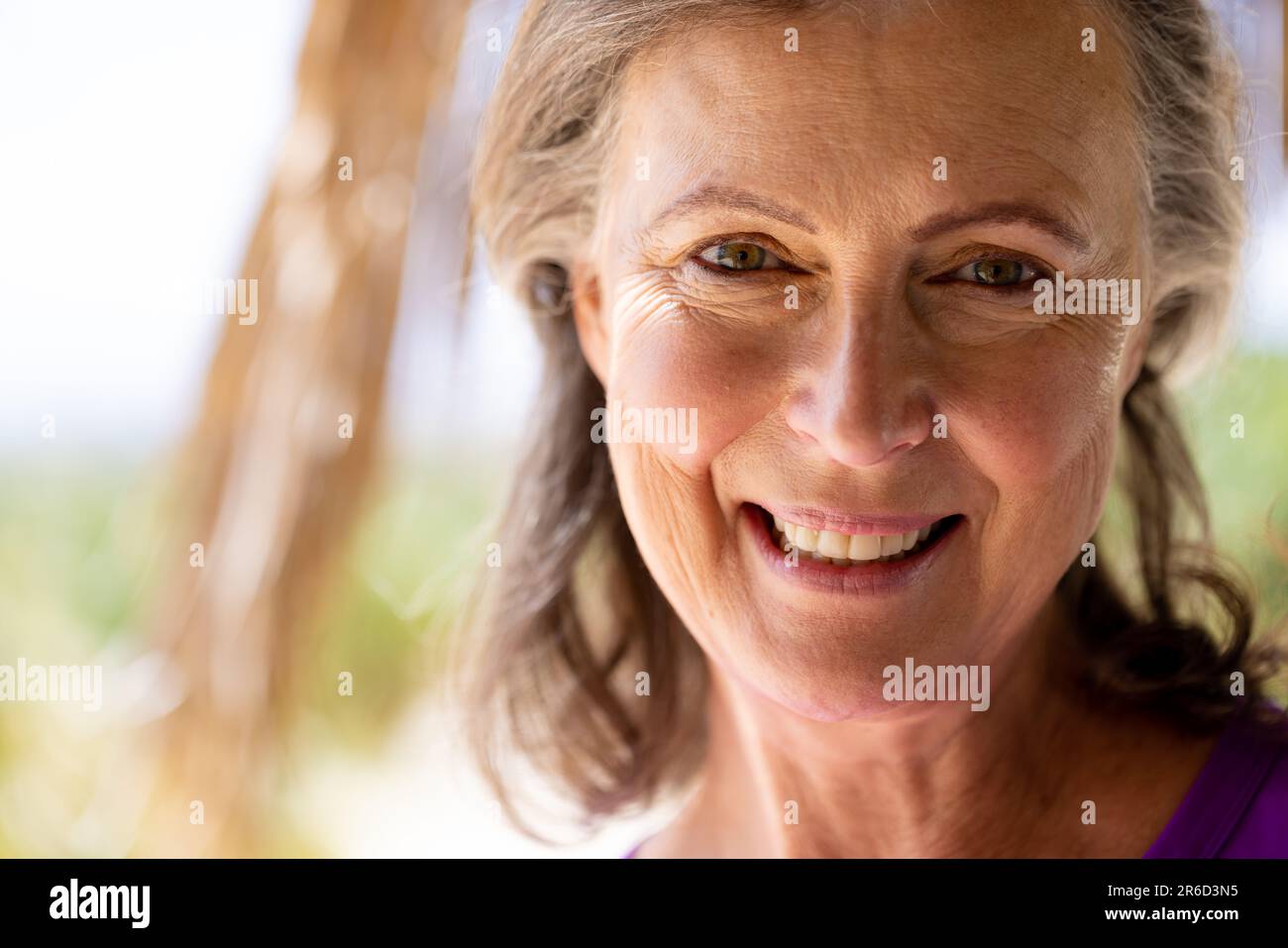 Nahaufnahme einer glücklichen, weißen, wunderschönen Seniorin mit braunen Augen, die in die Kamera schauen Stockfoto