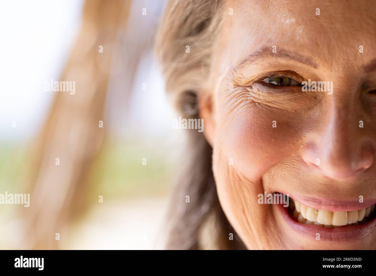 Nahaufnahme einer weissen Seniorin mit braunen, lächelnden und vor die Kamera schauenden Augen Stockfoto