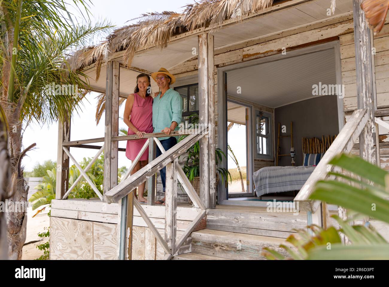 Kaukasisches glückliches Seniorenpaar, das am Geländer stand, auf dem Balkon einer Holzhütte, Kopierraum Stockfoto