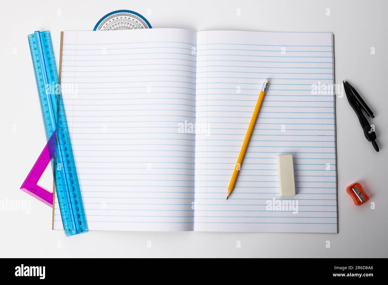 Nahaufnahme des Notizbuchs mit Linealen und Schreibmaterial auf weißem Hintergrund. Schulmaterial, Mathematik, Schreiben, Zeichnen, Lernen, Schule und Bildung Stockfoto