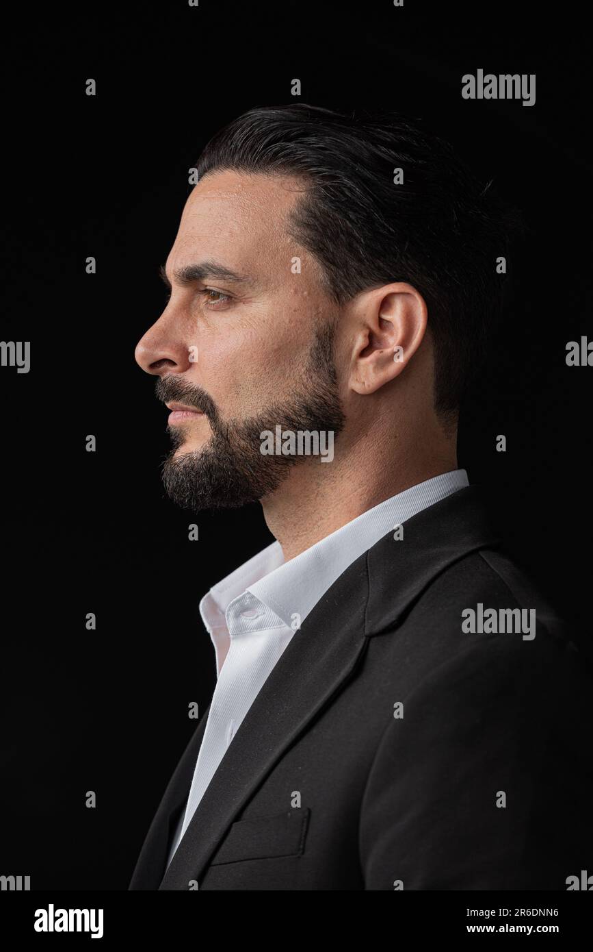 Profilansicht Porträt eines gutaussehenden Geschäftsmannes vor schwarzem Hintergrund Stockfoto