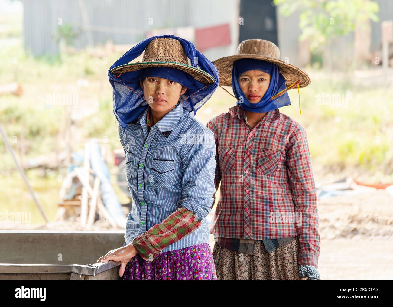 Zwei junge Arbeiterinnen auf einer Fischfarm im Irrawaddy Delta in Myanmar. Geringe Schärfentiefe mit nur der Frau links im Fokus. Stockfoto