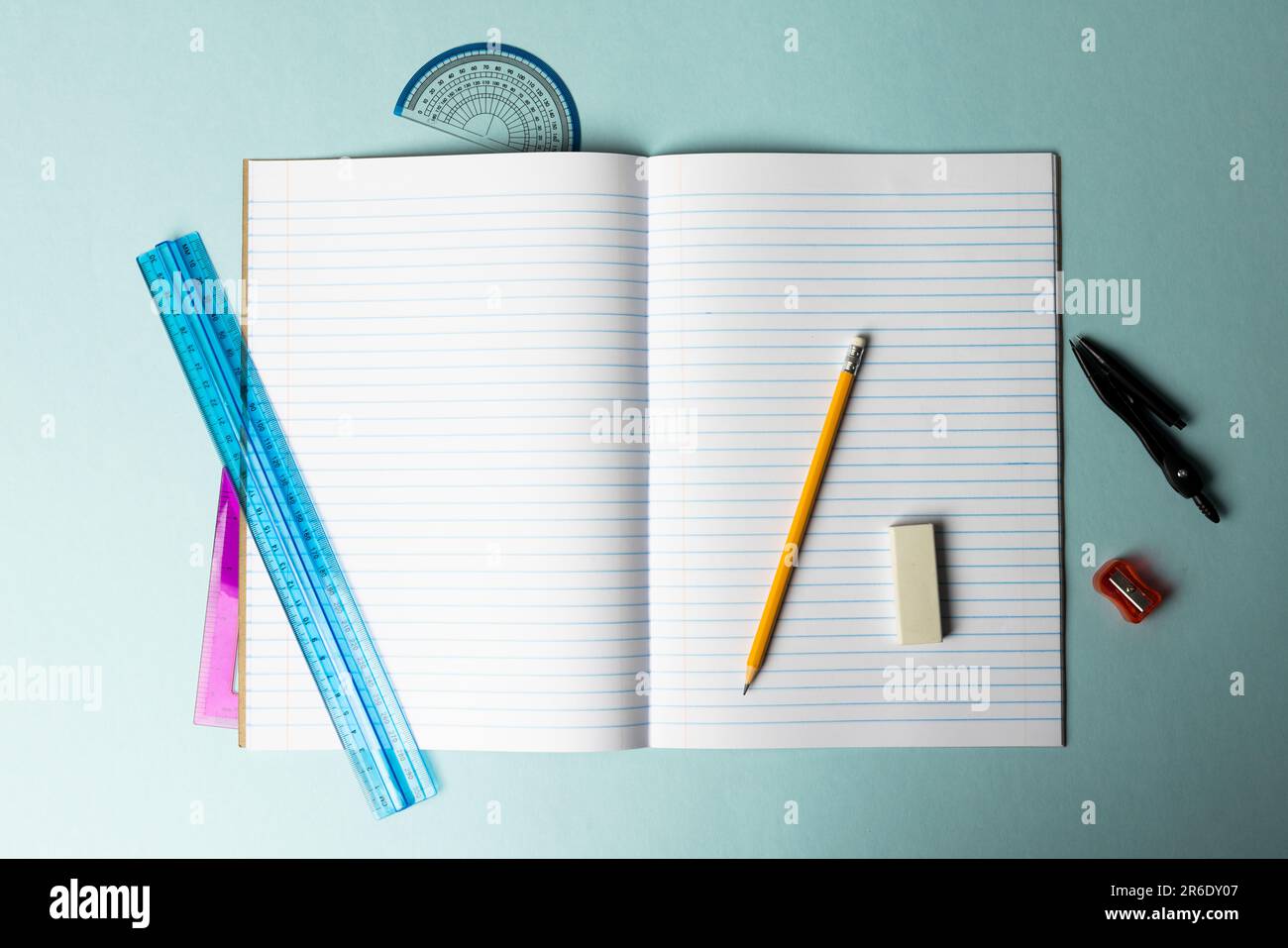 Nahaufnahme des Notizbuchs mit Linealen und Schreibmaterial auf blauem Hintergrund. Schulmaterial, Mathematik, Schreiben, Zeichnen, Lernen, Schule und Bildung Stockfoto