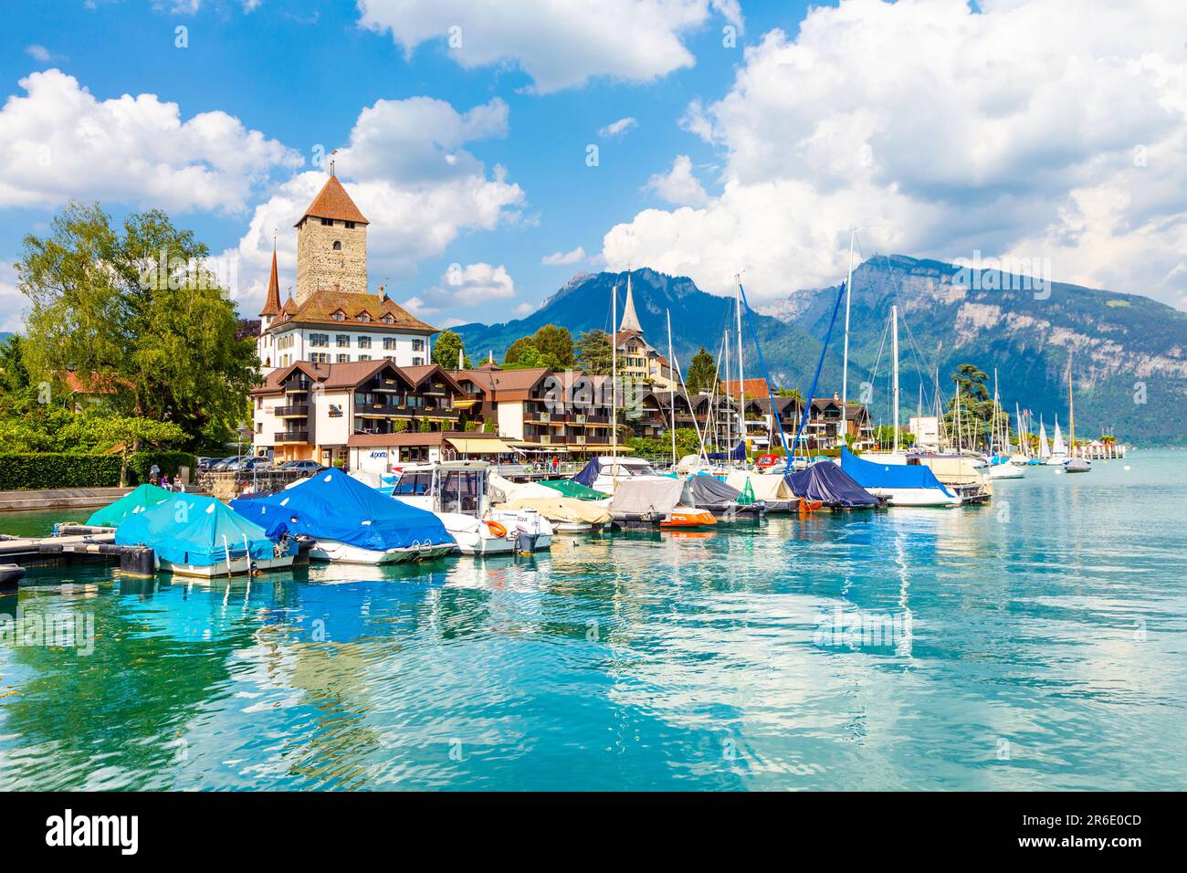 Boote auf dem Thunersee im Jachthafen von Spiez mit Schloss Spiez im Hintergrund, Spiez, Schweiz Stockfoto