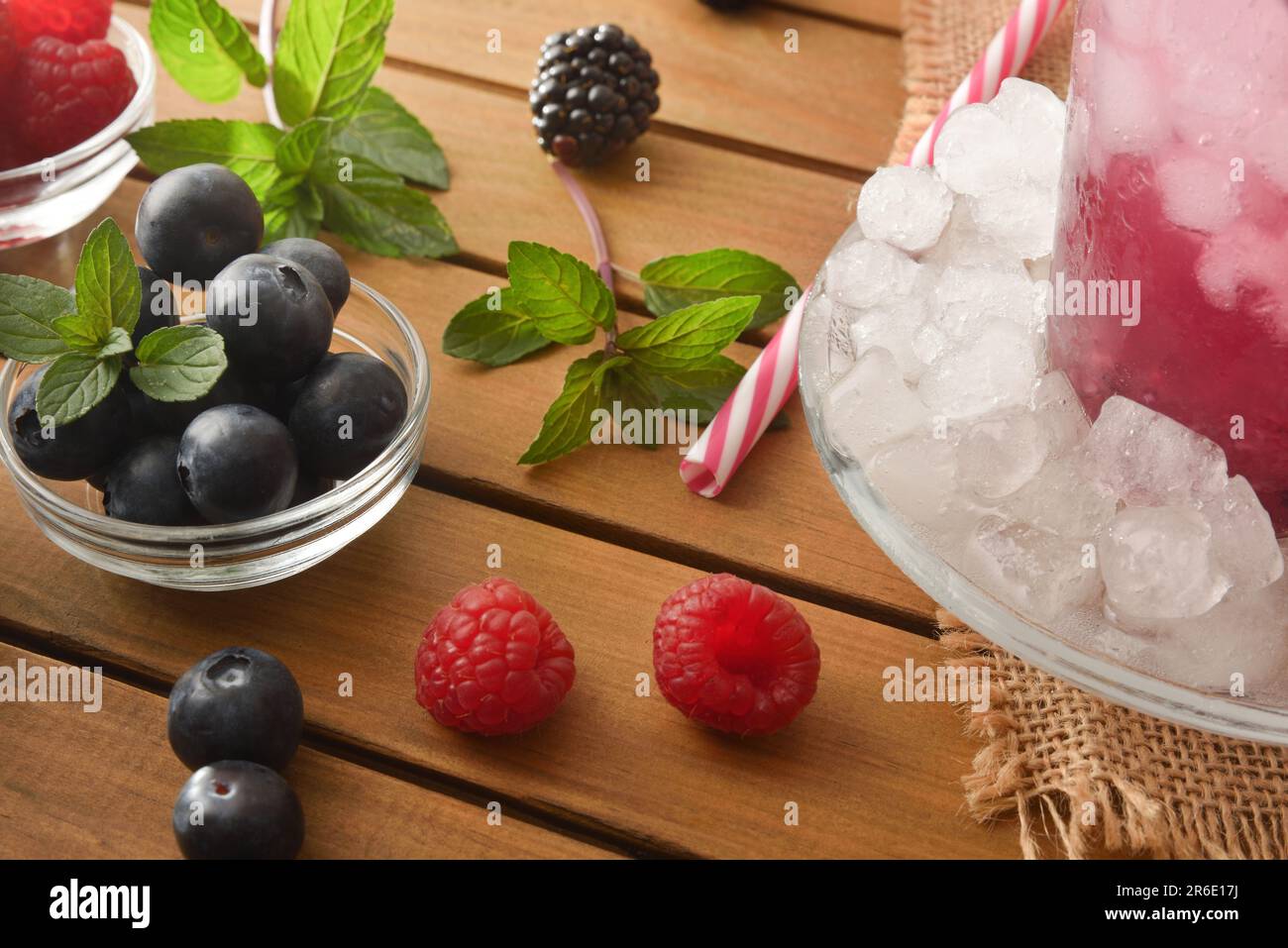 Details eines Erfrischungsgetränks mit Waldfrüchten und einem Glas Beerensaft mit Eis und Früchten. Erhöhte Aussicht. Horizontale Zusammensetzung. Stockfoto