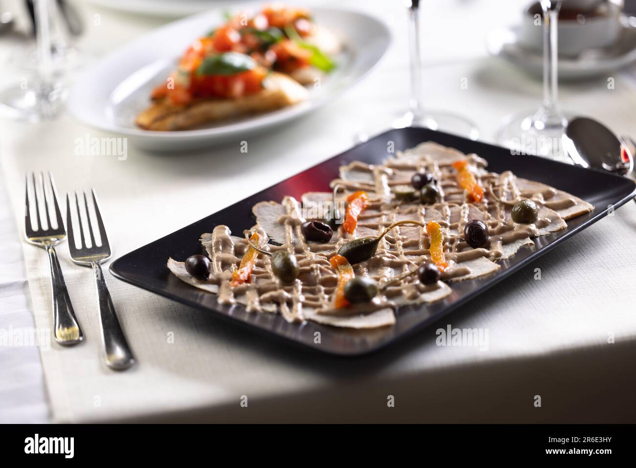 Italienische Vorspeise mit Kalbfleisch, Thunfischsalsa und Oliven in einem italienischen Restaurant. Stockfoto