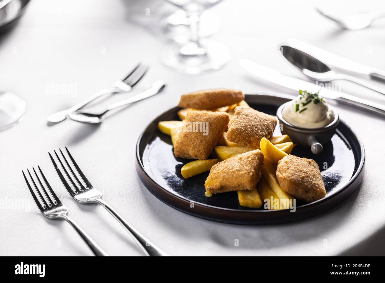 Panierte Käsestücke, gebraten mit pommes frites und serviert mit Mayonnaise. Kindermenü im schicken Restaurant mit Chicken Nuggets und Kartoffelsplittern. Stockfoto