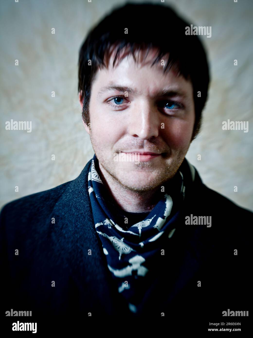 Porträt eines jungen Mannes mit blauem Schal und blauen Augen. Stockfoto