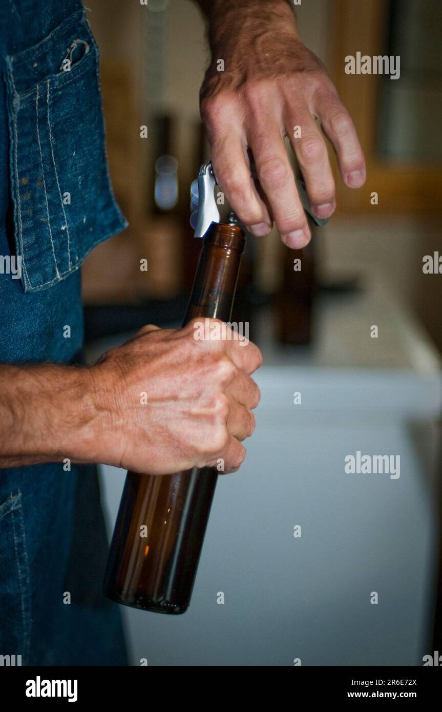 Ein Mead-Maker, öffnet eine Flasche Mead-Honig. Stockfoto