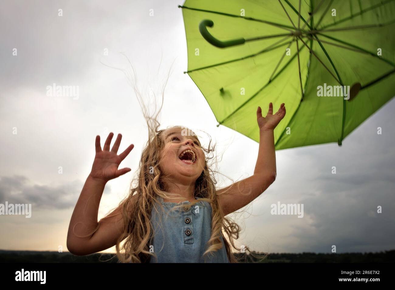 Kleines Mädchen mit Schirm und großem Lächeln Stockfoto