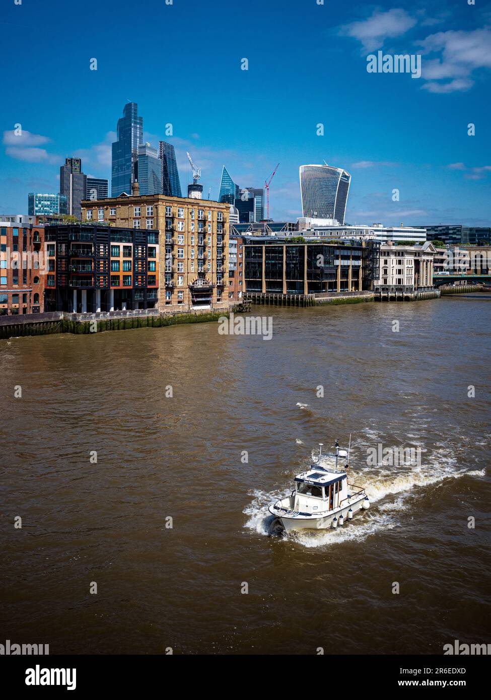 River Thames City of London – ein kleines Boot fährt auf der Themse durch den City of London Financial District. Stockfoto