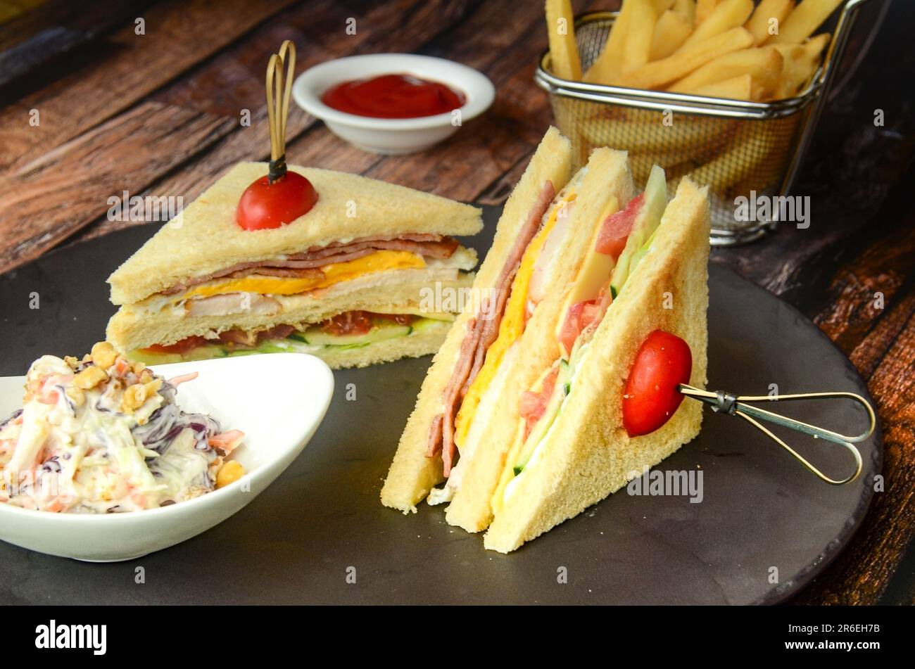 Ein schwarzer Teller mit Sandwiches, pommes Frites und Salat Stockfoto