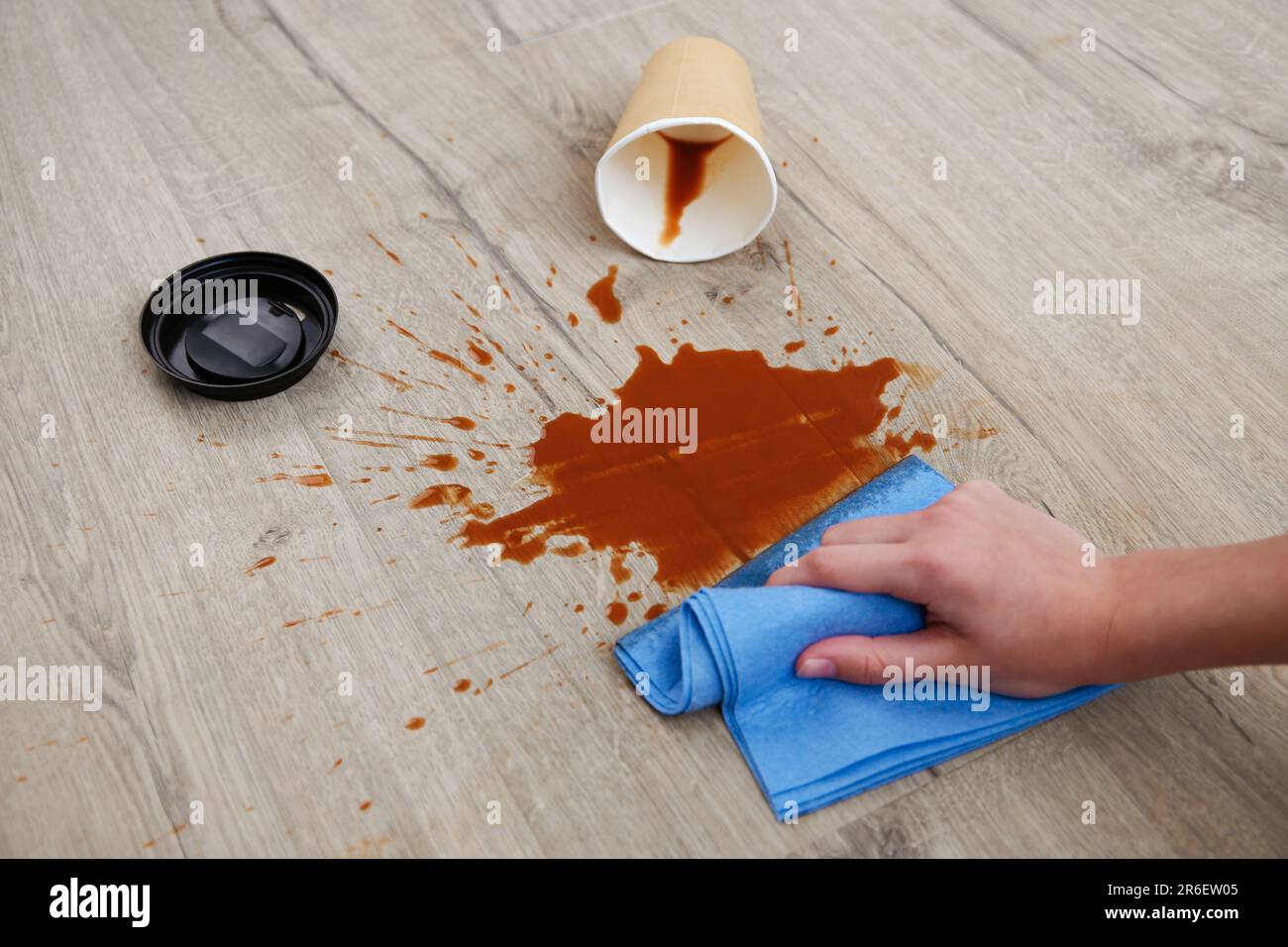 Pappbecher Kaffee fiel auf Laminat, Kaffee verschüttete auf den Boden. Stockfoto