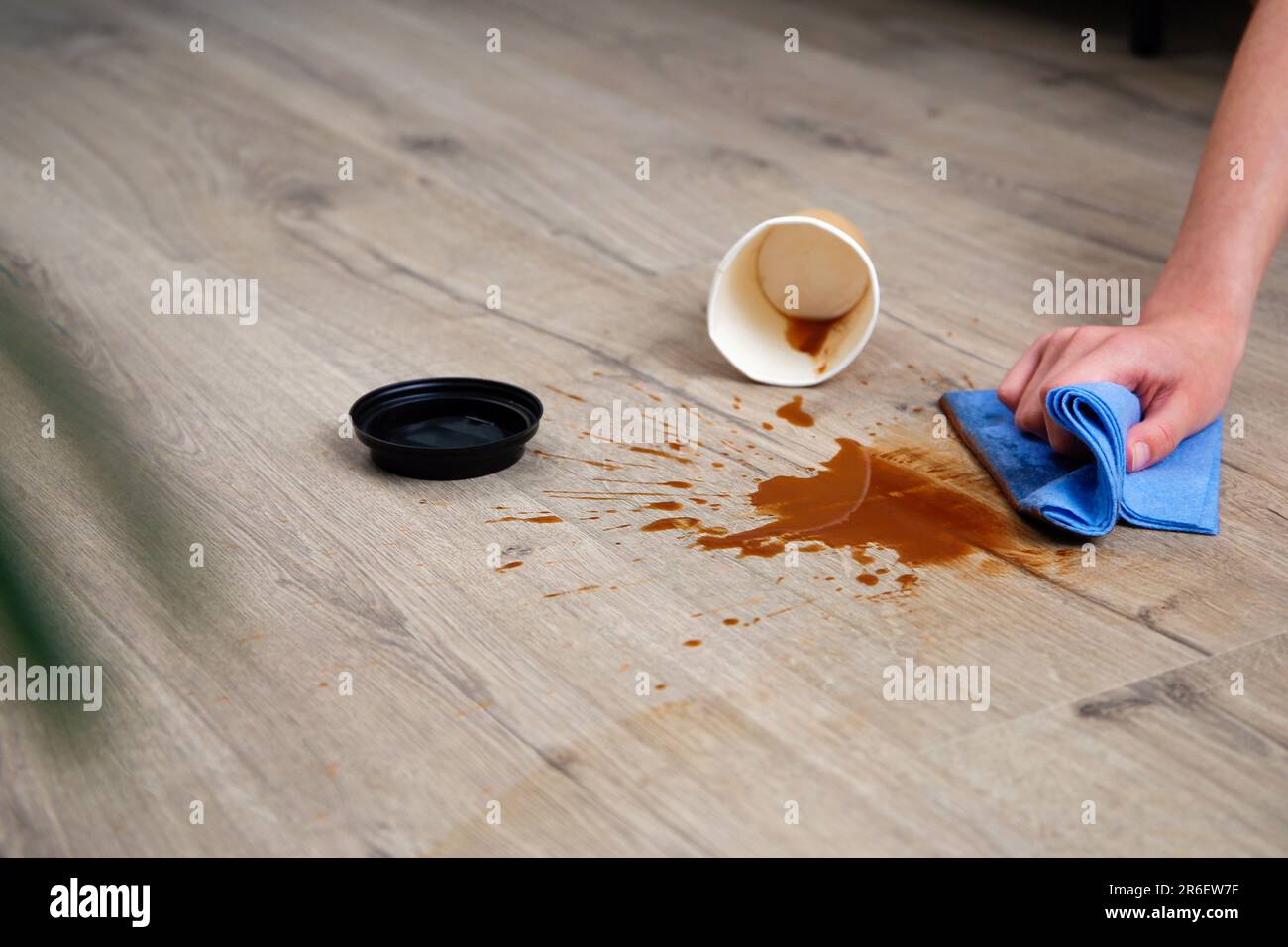 Pappbecher Kaffee fiel auf Laminat, Kaffee verschüttete auf den Boden. Stockfoto