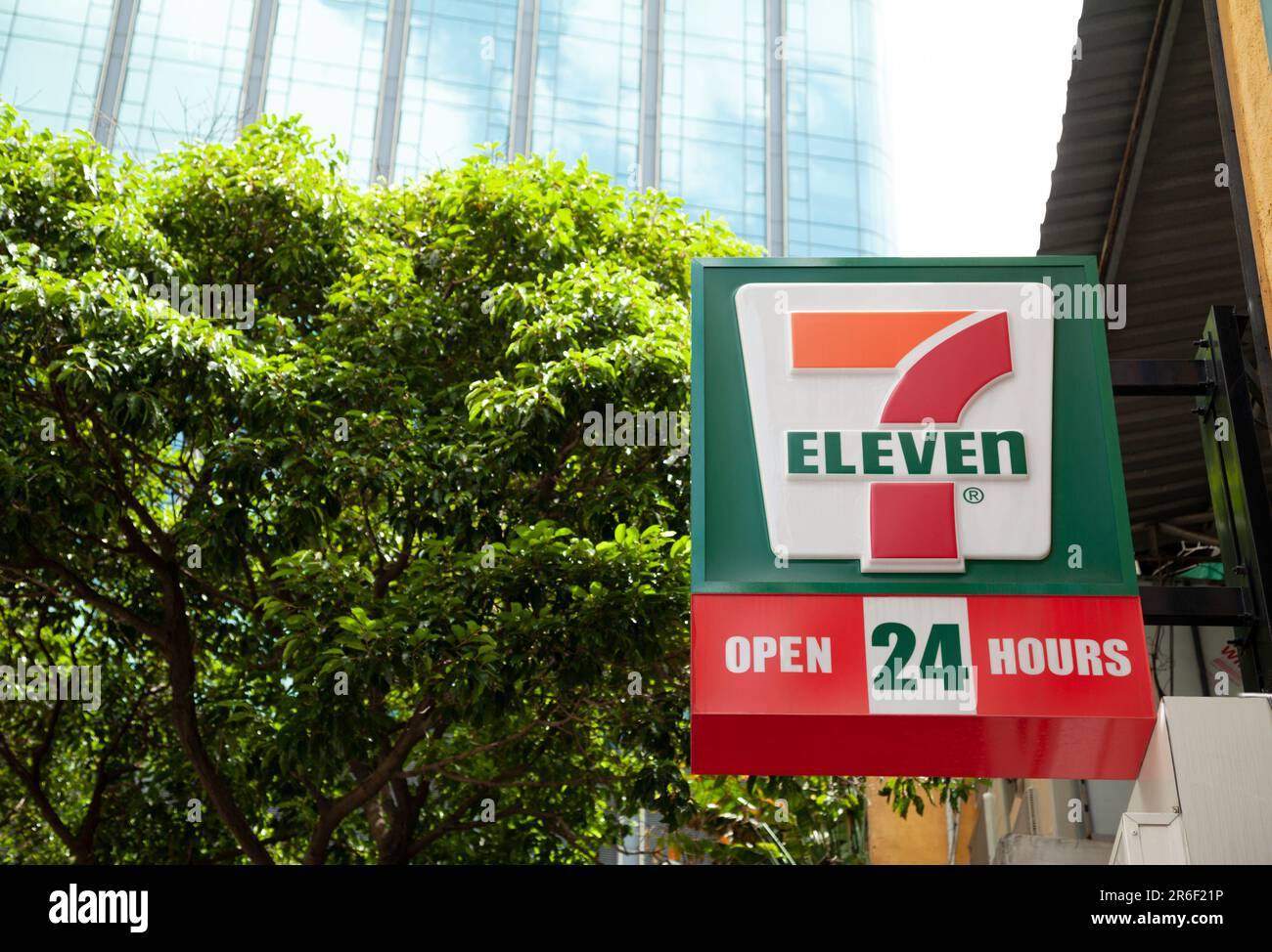 Ho-Chi-Minh-Stadt, Vietnam - 4. Juni 2023: Grünes und rotes Informationsschild mit 7-11-Logo auf einem 24-Stunden-Geschäft. Lightbox-Werbung außerhalb eines g. Stockfoto