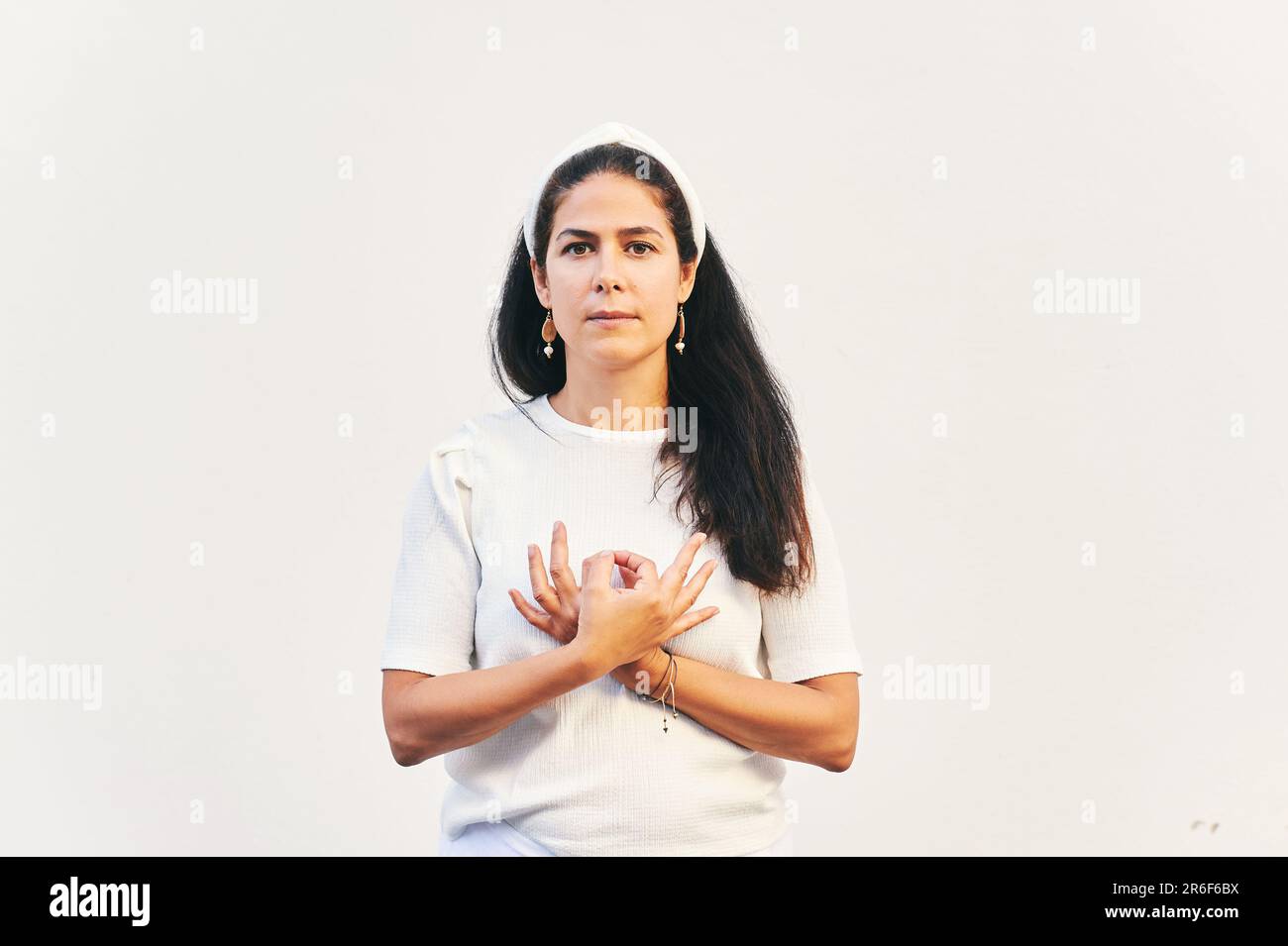 Porträt einer Frau, die Gyan Mudra neben dem Herzen hält, Handposition aus Kundalini Yoga Meditation Love is Love. Diese Meditation entfernt jede Dualitätswette Stockfoto